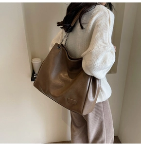 Dettaglio borsa tote vintage marrone con tracolla a catena metallica ed etichetta