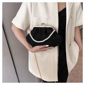 Detail of black pleated lace bag with vintage gold clasp and pearl handle strap