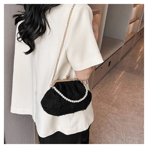 Detail of black lace cloud bag with white pearl handle and gold metal chain strap