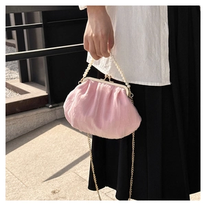 Detailed view of pink pleated cloud bag with white pearl handle and gold chain strap