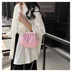Detailed view of pink pleated cloud bag with pearl handle and metal chain strap