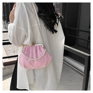 Pink cloud-shaped pleated bag with pearl handle and golden chain worn on shoulder