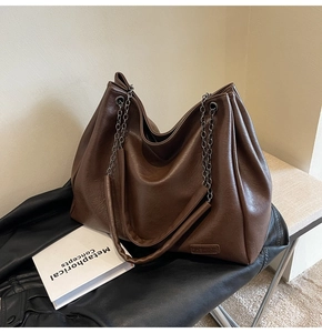 Dettaglio della borsa tote vintage con tracolla a catena e incisione FASHION