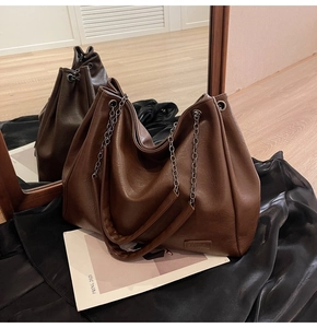 Dettaglio della borsa tote marrone scuro che mostra la trama in ecopelle e l'etichetta