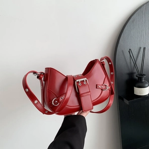 Dark red crescent shoulder bag with vintage silver buckle and eyelet strap detail