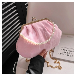 Detail of pink pleated cloud bag featuring a pearl handle and gold chain strap