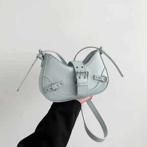 Light blue crescent hobo bag with motorcycle-style studs and silver metal buckles