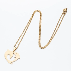 Detailed view of gold-toned necklace with dual dolphins forming a heart pendant