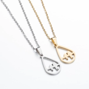Detailed view of silver and gold teardrop pendants featuring hollow pet silhouette