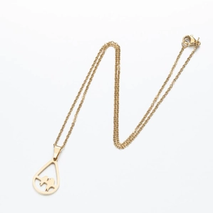 Detail of gold stainless steel necklace featuring a teardrop pendant with couple silhouette