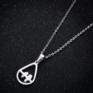 Macro shot of silver bird silhouette pendant on a shimmering black starry background