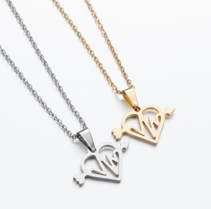 Detail of gold and silver heart-shaped pendant necklaces with arrow design elements