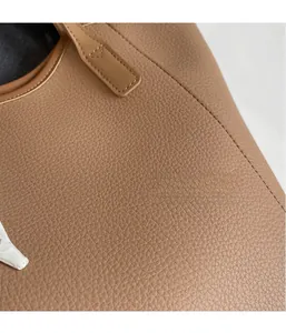Close-up of brown litchi pattern leather tote bag with reinforced stitching details
