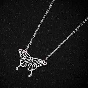 Minimalist silver butterfly pendant necklace with intricate hollow geometric design on black
