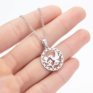 Detailed close-up of a silver hummingbird pendant with intricate镂空 floral patterns