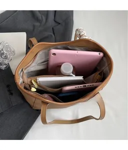 Interior view showing large capacity and compartments of the brown leather tote bag