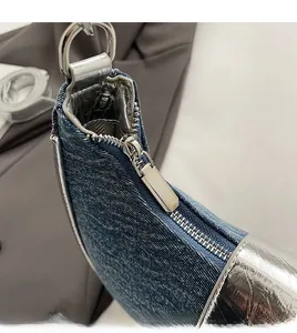 Detail of denim shoulder bag with silver mirror trim and smooth metallic zipper