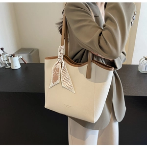 Detail view of large cream leather tote bag with brown straps and floral silk scarf