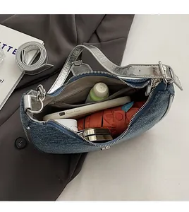 Top view of blue denim baguette bag interior showing spacious capacity for phone and umbrella