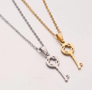 Detailed view of hollow clover key pendants in gold and silver stainless steel