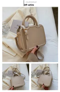 Detail view of cream-colored leather handbag with embossed texture and gold hardware