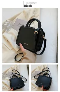 Detail of black minimalist biscuit bag with gold lettering and top handle in lifestyle setting