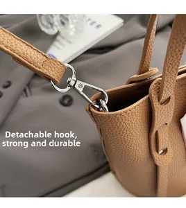 Detail of silver swivel lobster clasp and detachable strap on brown lychee leather bag