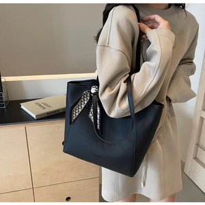 Detail of black lychee grain leather tote bag with geometric silk scarf decoration