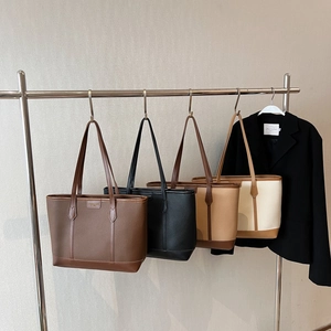 Multiple colors of large capacity lychee textured tote bags hanging on a rack
