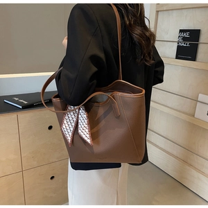 Brown litchi leather tote bag detail with decorative silk scarf on the handle