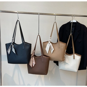 Detail of four faux leather tote bags in various colors with silk scarf handle wraps