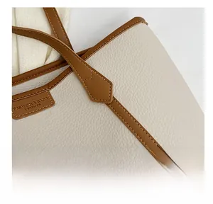Close-up of reinforced stitching and fashion leather logo on contrast tote bag