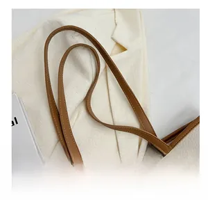 Detail showing high-quality lychee pattern texture and brown leather handle connections