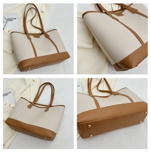 Detail view of large tote bag with contrast lychee grain leather and protective gold metal studs