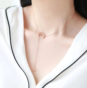 Rose gold moon and star tassel necklace worn by a model for a minimalist jewelry look