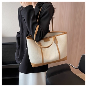 Lifestyle shot of large faux leather tote bag with contrasting brown straps and trim