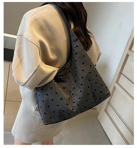 Detailed view of grey canvas tote bag with black polka dots and small bows pattern