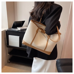 Detail view of large capacity tote bag with contrast lychee grain leather on model