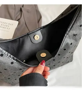 Detailed macro view of the gold magnetic closure and polka dot canvas interior