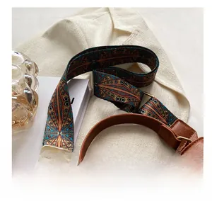 Close-up of ethnic jacquard woven strap with geometric patterns and golden metal buckle