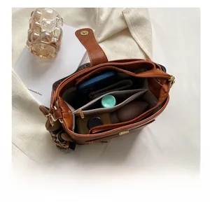 Top view of vintage brown bucket bag showing multi-compartment interior and bear charm