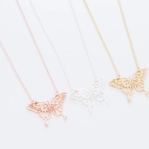 Détail des pendentifs papillon origami évidés en finitions or rose, argent et dorée