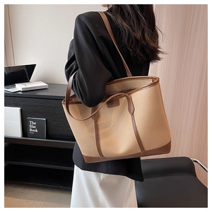 Detailed side view of large beige and brown lychee grain tote bag on model shoulder