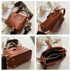 Detail view of vintage brown bucket bag with floral strap and plush bunny charm