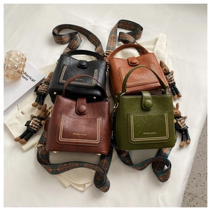 Four vintage bucket bags in black, brown, and green with bohemian patterned straps