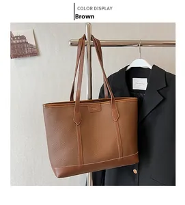 Detail of brown litchi pattern tote bag hanging with professional office attire