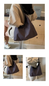 Close-up of a large grey canvas tote bag with red heart patterns and black wide strap