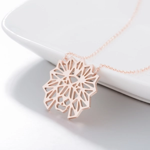 Détail du pendentif tête de lion géométrique en or rose avec chaîne à mailles croisées
