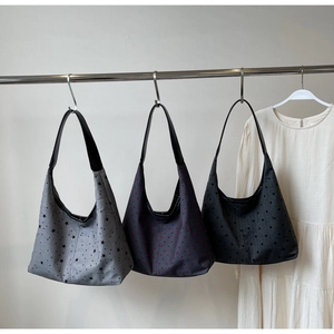 Detailed display of three canvas tote bags with star, heart and polka dot patterns