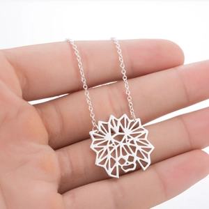 Détail macro d'un collier en acier inoxydable avec pendentif lion creux géométrique